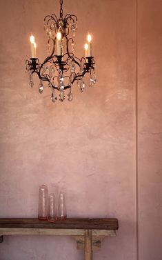 a chandelier hanging from the ceiling over a table with two glasses on it