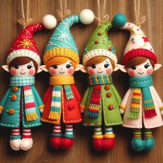 three christmas ornaments hanging from strings on a wooden surface with snowflakes and hats