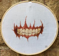 the embroidery is being stitched on to a piece of fabric that looks like teeth