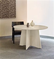 a white table with two vases sitting on top of it next to a black chair