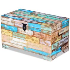 an old trunk is painted with multicolored wood and has a black latch on the lid