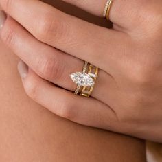 a woman's hand with two rings on her left and one ring on her right