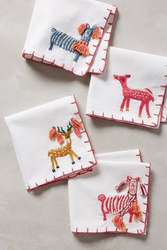 four embroidered napkins with animals on them