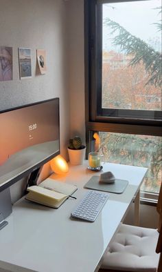 a computer desk with a keyboard, mouse and monitor on it in front of a window