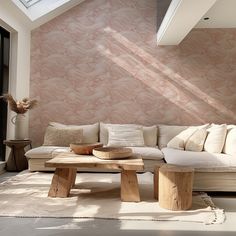 a white couch sitting under a skylight in a living room next to a wooden table