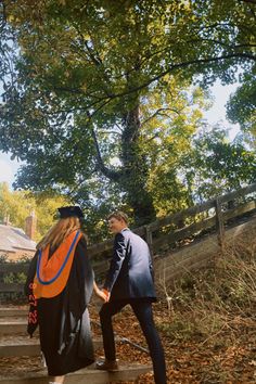 two people walking up some steps in the woods