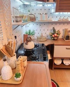 a stove top oven sitting inside of a kitchen next to a wooden table and counter