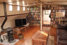 a living room filled with lots of books and furniture