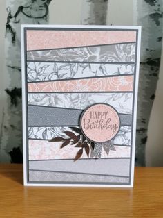 a close up of a birthday card on a wooden table with trees in the background