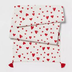 two red hearts on white fabric with tassels