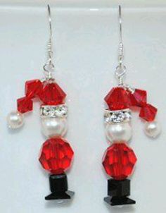 a pair of red and white beaded earrings with santa clause on it's head