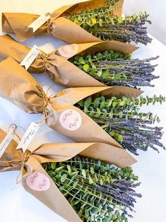 three bouquets of flowers are wrapped in brown paper and tied with twine ribbons