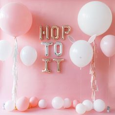 balloons and streamers with the word hop to it spelled out in gold letters on a pink background