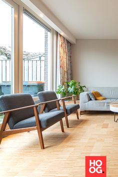 a living room filled with furniture and large windows