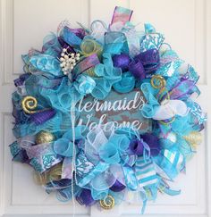 a wreath that says mermaids welcome hanging on a door