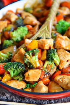 a bowl filled with chicken and broccoli on top of a table