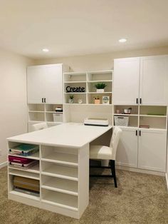 a white desk sitting in the middle of a room with lots of bookshelves