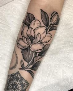 a black and white flower tattoo on the arm