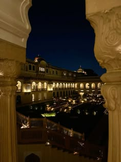 the view from an outside balcony at night, looking down on a building with many lights