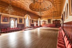 an empty ballroom with red chairs and chandeliers