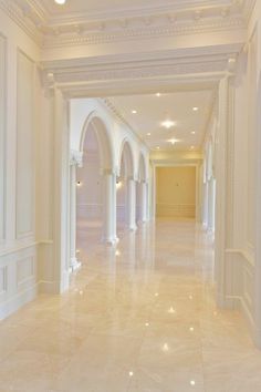 an empty hallway with white columns and arches