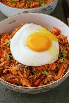 two bowls filled with rice and an egg on top