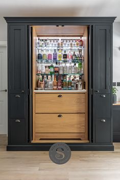 the bar is built into the wall and has many liquor bottles on display in it