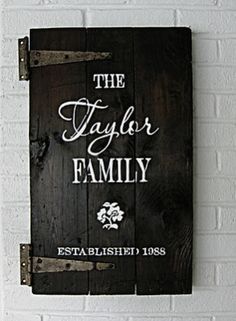 the taylor family sign is hanging on a brick wall