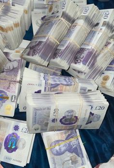 many stacks of money sitting on top of each other in front of a blue blanket