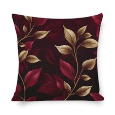 a decorative pillow with red and gold leaves on the front, against a black background