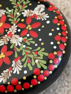 a black and red box with flowers painted on it