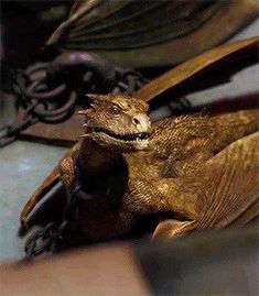 a close up of a bat laying on the ground with it's mouth open