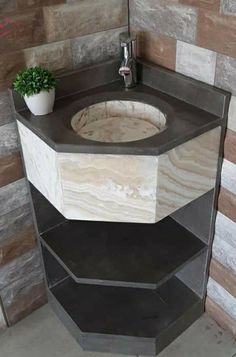 a bathroom sink made out of hexagonal blocks with a potted plant on top