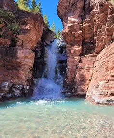 there is a waterfall in the middle of some rocks