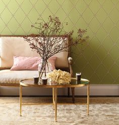 a living room with a couch, coffee table and vase on the floor in front of it