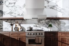 a stove top oven sitting inside of a kitchen next to wooden cabinets and counter tops