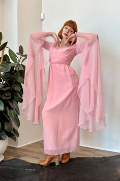 Vintage 1960s Dress / 60s Miss Elliette Angel Sleeve Dress / Pink ( XS S ) ~T H E R U N D O W N~ Modern Size: XS/S Materials: Acrylic chiffon Condition: Excellent vintage condition Brand: Miss Elliette ~F U L L D E T A I L S~ Absolutely epic '60s angel sleeve dress by Miss Elliette done in rose pink chiffon! Scoop neckline, banded empire waist with a bow at the back, maxi-length skirt, and insanely cool sheer sleeves that are fitted to the elbows before cascading to reach the floor. Zipper closure at the back, fully lined. ~ M E A S U R E M E N T S~ Shoulders: 16 inches Bust: 34-36 inches Waist: Up to 27 inches (empire) Hips: Up to 40 inches Length Shoulder to Waist: 14 inches Length Shoulder to Hem: 56 inches Sleeve circumference: 13 inches (above elbow) ♥ More vintage dresses https://www Angel Witch, 60s Fashion Women, Angel Sleeve Dress, Angel Sleeves Dress, Vintage Dresses 1960s, 1960s Dress, 1960's Dress, Pink Chiffon, Angel Sleeve