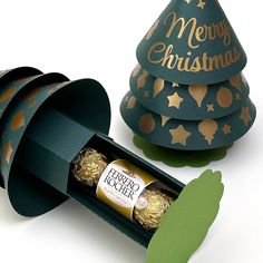 a christmas tree shaped box with chocolates in it and some cut out paper on the side