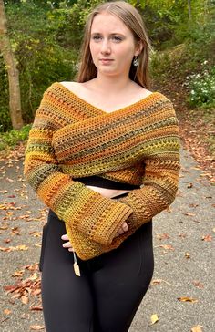 a woman in black leggings and a yellow knitted sweater is posing for the camera