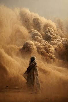 a man standing in the desert surrounded by dust