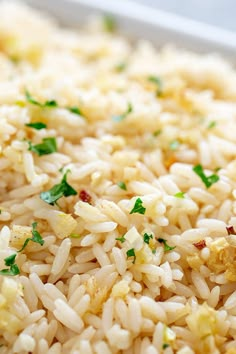 rice with parsley on top in a white dish