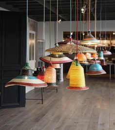 many different colored lamps hanging from the ceiling