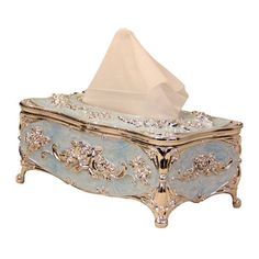 a tissue dispenser sitting on top of a blue box with gold trim