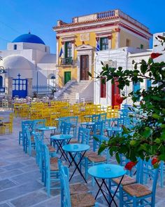 tables and chairs are lined up in front of colorful buildings