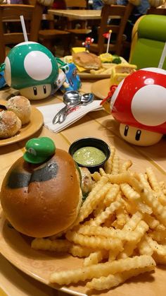 a mushroom burger and french fries are on a plate at a table with other food items