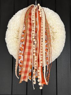 an orange and white wreath hanging from a door