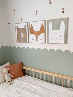 a baby's room with three pictures on the wall and a teddy bear in bed