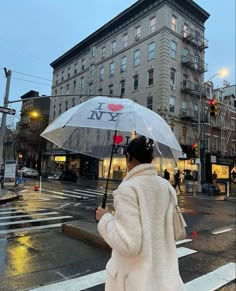 a woman in a white coat is holding an umbrella