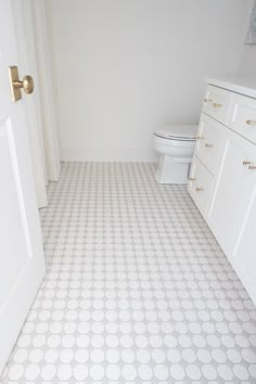 a bathroom with a toilet and white cabinets