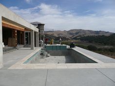 people are standing on the roof of a house with an above ground swimming pool in the foreground